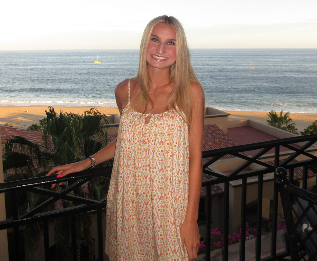 Heiner Orthodontics Patient Standing On A Balcony Above A Beach